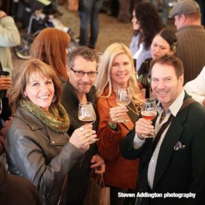 A group of people holding drinks at an event.