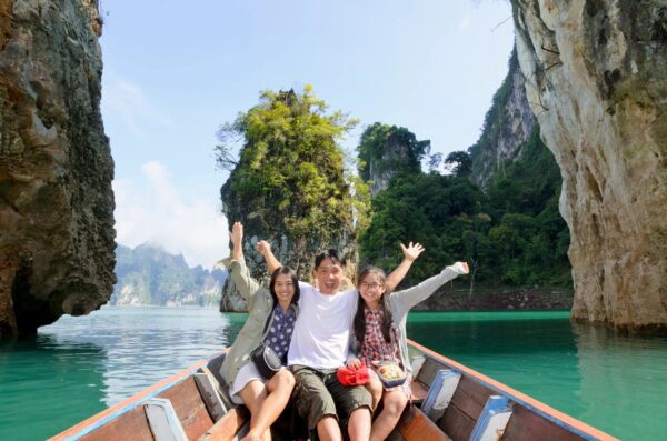 Three people on a boat in the water.