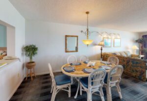 A dining room table with chairs and a plant in the middle.