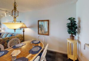 A dining room table with blue place mats and napkins.