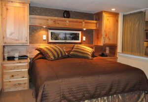 A bed room with a brown and white bedspread