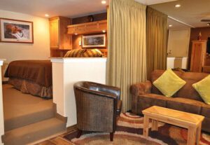 A living room with brown leather furniture and a couch.