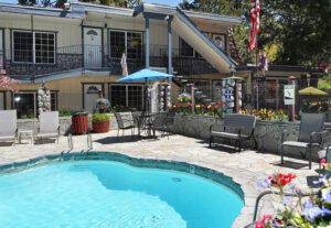 A pool with chairs and an umbrella in the background.