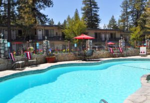 A pool with chairs and umbrellas in the background.