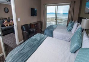 A bedroom with two beds and a tv on the wall.