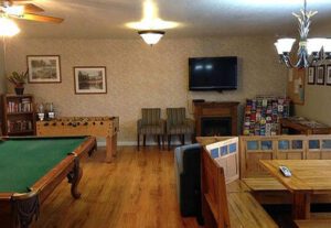 A room with a pool table and a television.