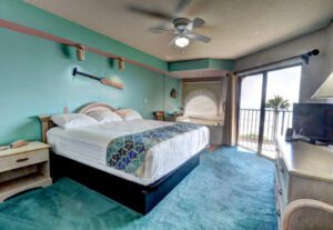 A bedroom with a bed, dresser and window.