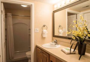 A bathroom with a sink, mirror and toilet.