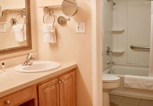 A bathroom with a sink, mirror and toilet.