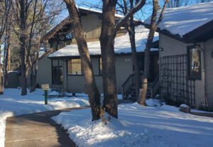 A house with snow on the ground and trees