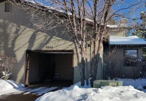 A garage with snow on the ground and trees