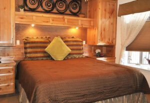 A bed room with a brown and yellow bedspread