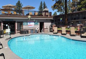 A pool with chairs and umbrellas in the background.