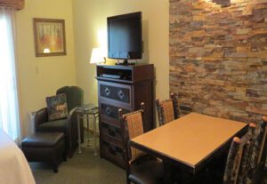 A room with a table, chairs and television.