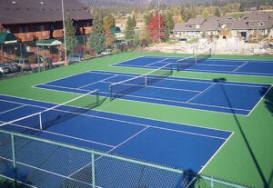 A tennis court with many different colors of blue and green.