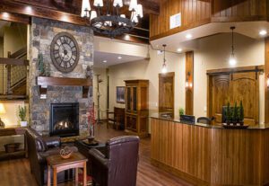 A living room with wood paneling and a fireplace.