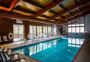 A large indoor swimming pool with chairs around it.