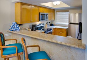 A kitchen with a counter and chairs in it