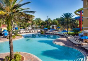 A pool with many chairs and umbrellas in it