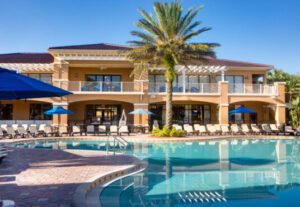 A large pool with palm trees and a building