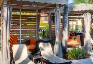 A patio with chairs and tables in the back yard.