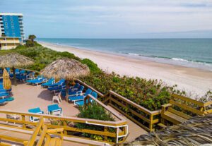 A beach with chairs and umbrellas on the sand.