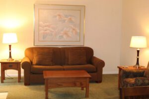 Living room with couch, floral painting, and lamps.