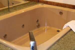 Brown bathtub with jets and towel.