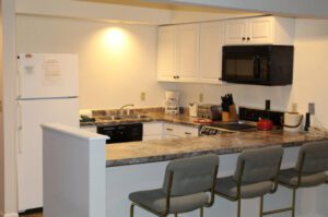 White kitchen with island and bar stools.