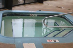 A blue tiled hot tub with water.