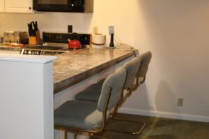 Kitchen counter with three bar stools.