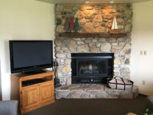 Stone fireplace with TV and a bag.