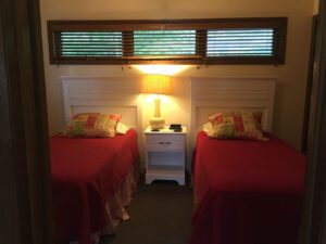 Two twin beds in a bedroom with a lamp.