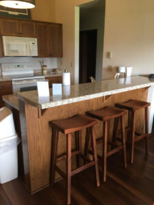 Three wooden bar stools in kitchen.