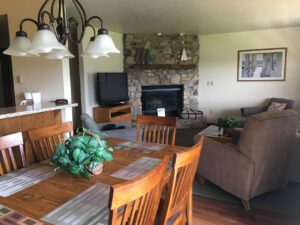 Dining room table with chairs and a fireplace.