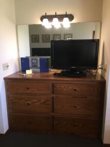 Wooden dresser with TV and stereo.