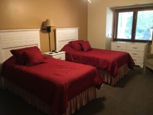 Two twin beds with red bedding in a bedroom.