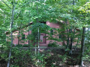 A red house surrounded by trees.