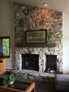 Stone fireplace with black iron doors.