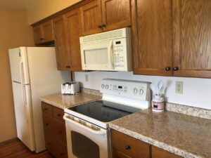 Kitchen with white appliances and wood cabinets.