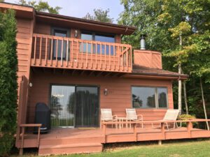 Brown cabin with deck and chairs.