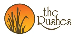 The Rushes logo with a sunset and reeds.