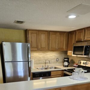 Stainless steel kitchen with wood cabinets.