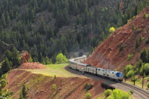 Passenger train winding through mountain pass.