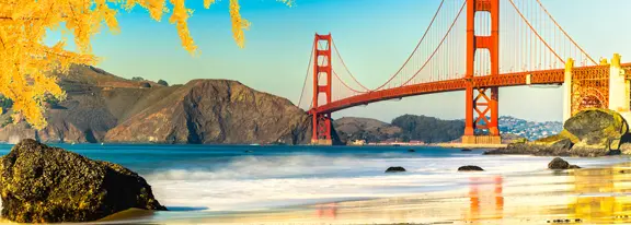 Golden Gate Bridge with beach and trees.