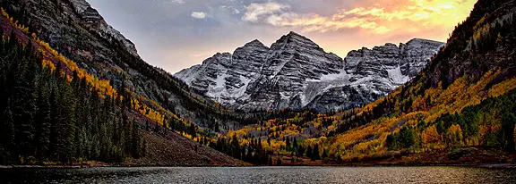 Snow-capped mountains reflected in a lake.