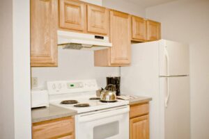 White kitchen with wood cabinets and appliances.