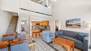 Open-plan living room with kitchen and staircase.