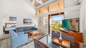 Modern hotel room with balcony and TV.