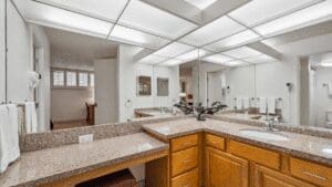 Modern bathroom with granite countertops and mirrors.